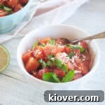 Bowl of Watermelon Feta Salad with balsamic vinegar on top and garnished with mint.