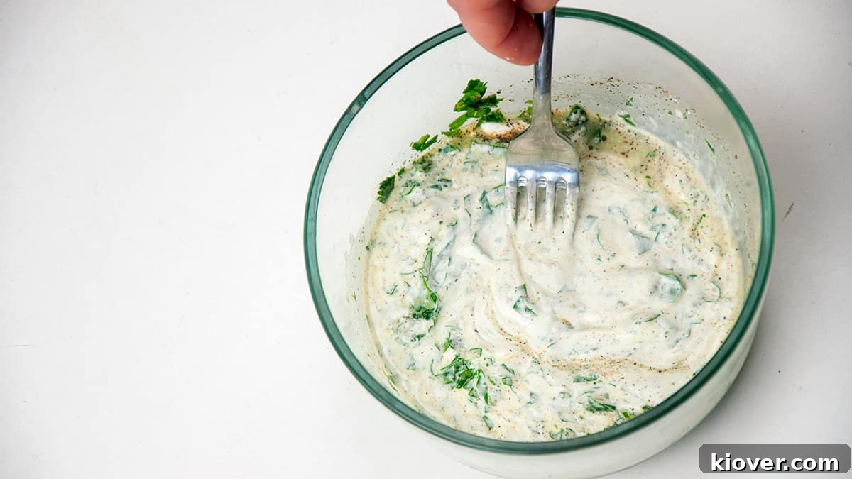 Mixed Cilantro Lime Sauce Cilantro Lime sauce in a bowl with a fork in it, ready for serving.