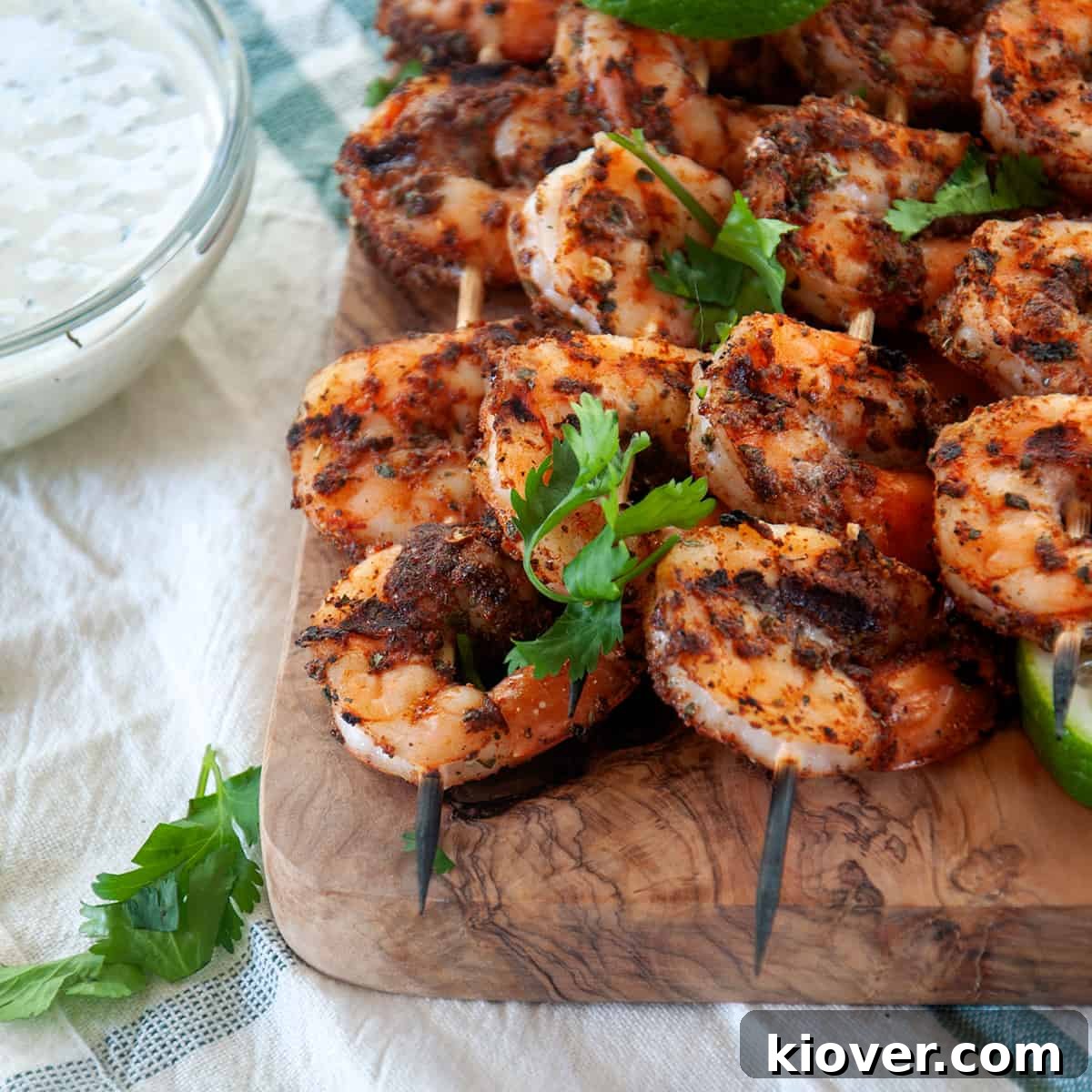 Serving Grilled Blackened Shrimp Four shrimp skewers served on a wood cutting board, ready to be enjoyed.