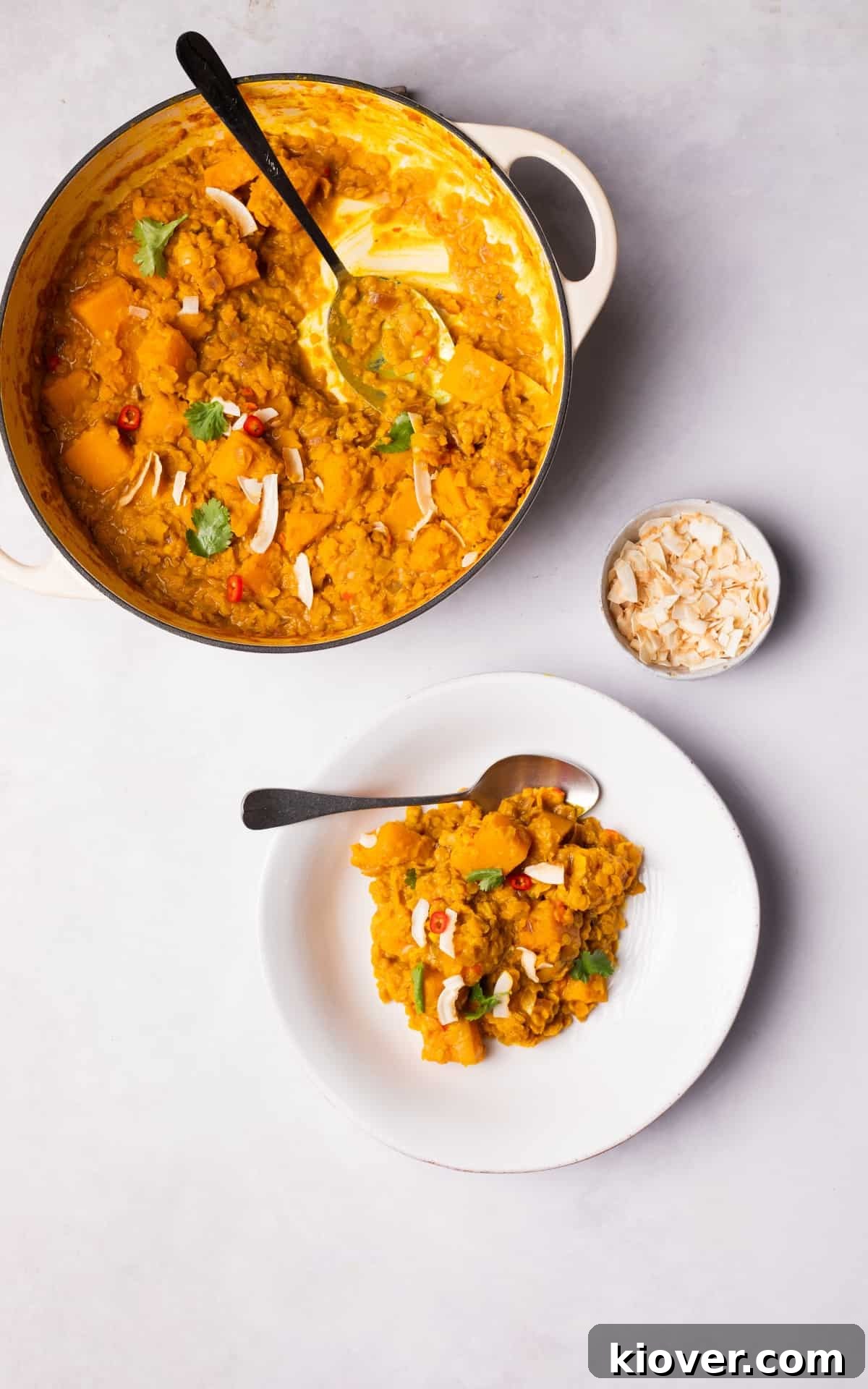 Butternut squash and coconut dhal served in a bowl, garnished with fresh coriander and coconut flakes.