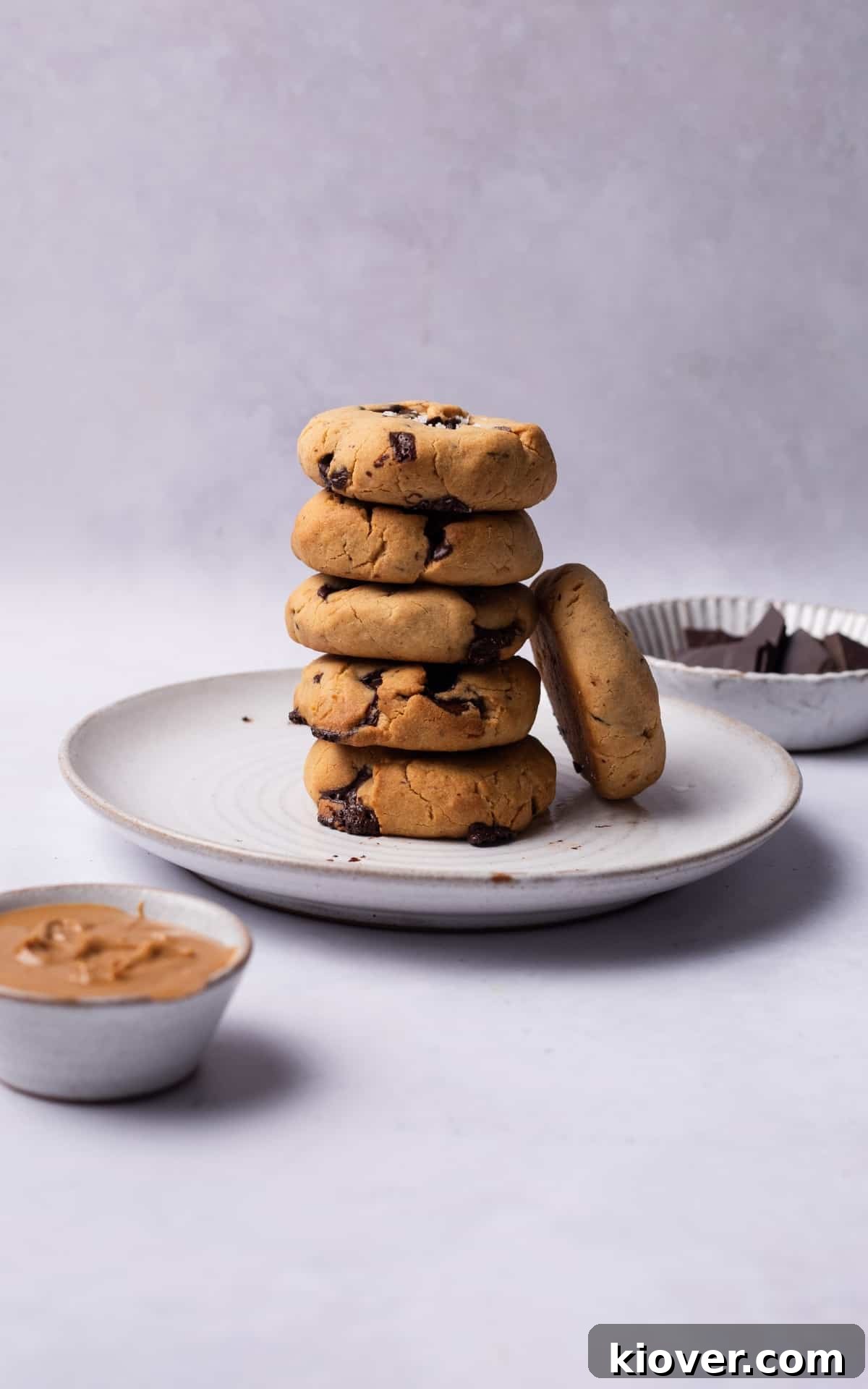 A stack of perfectly baked vegan peanut butter cookies with visible chocolate chunks, invitingly placed on a plate.