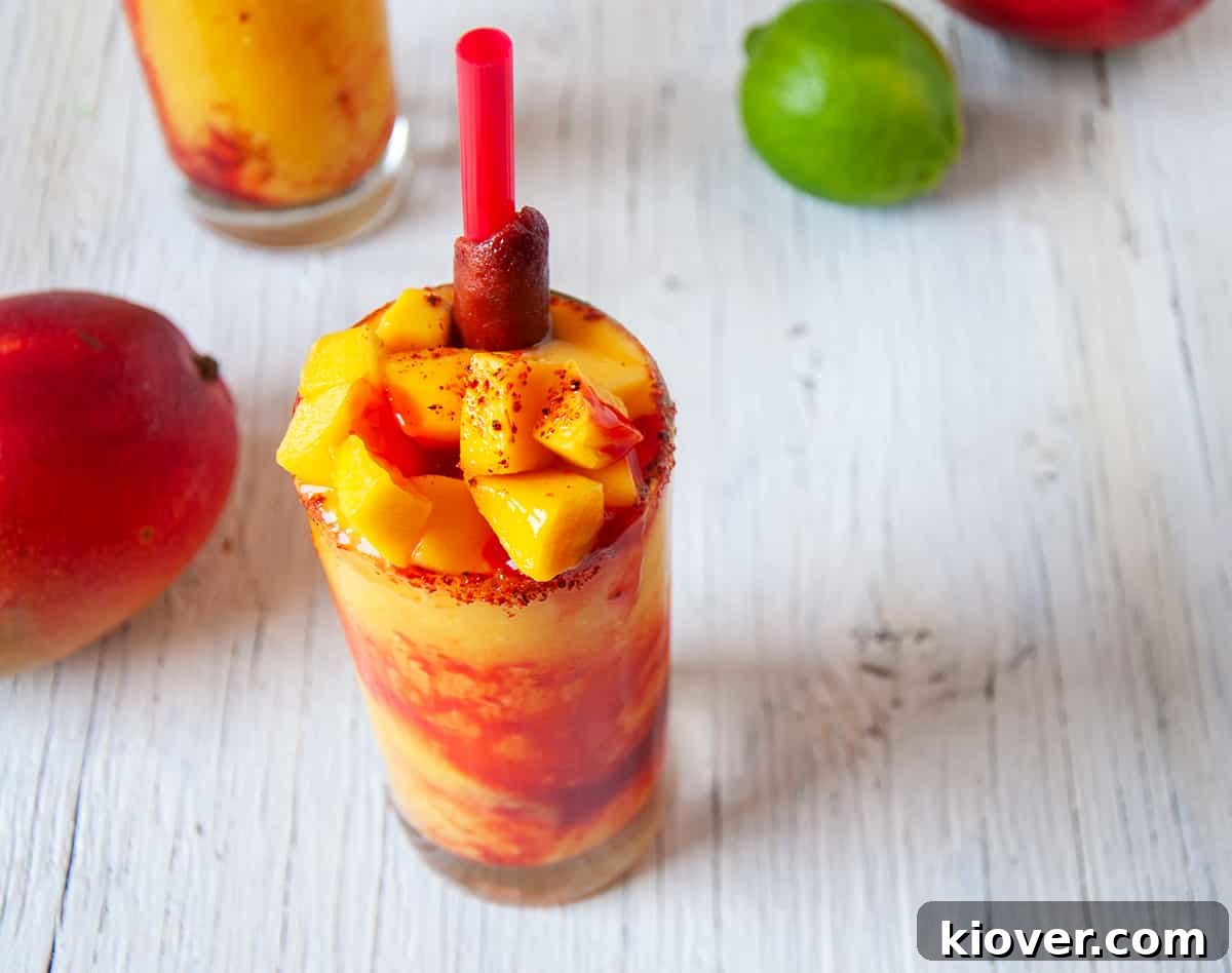 Mangonada with fresh mango on top, chamoy sauce, and Tajin.