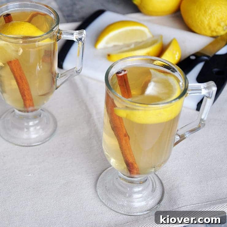 Best Hot Toddy recipe, elegantly presented on a table with fresh lemon slices, cinnamon sticks, and a rustic cutting board.