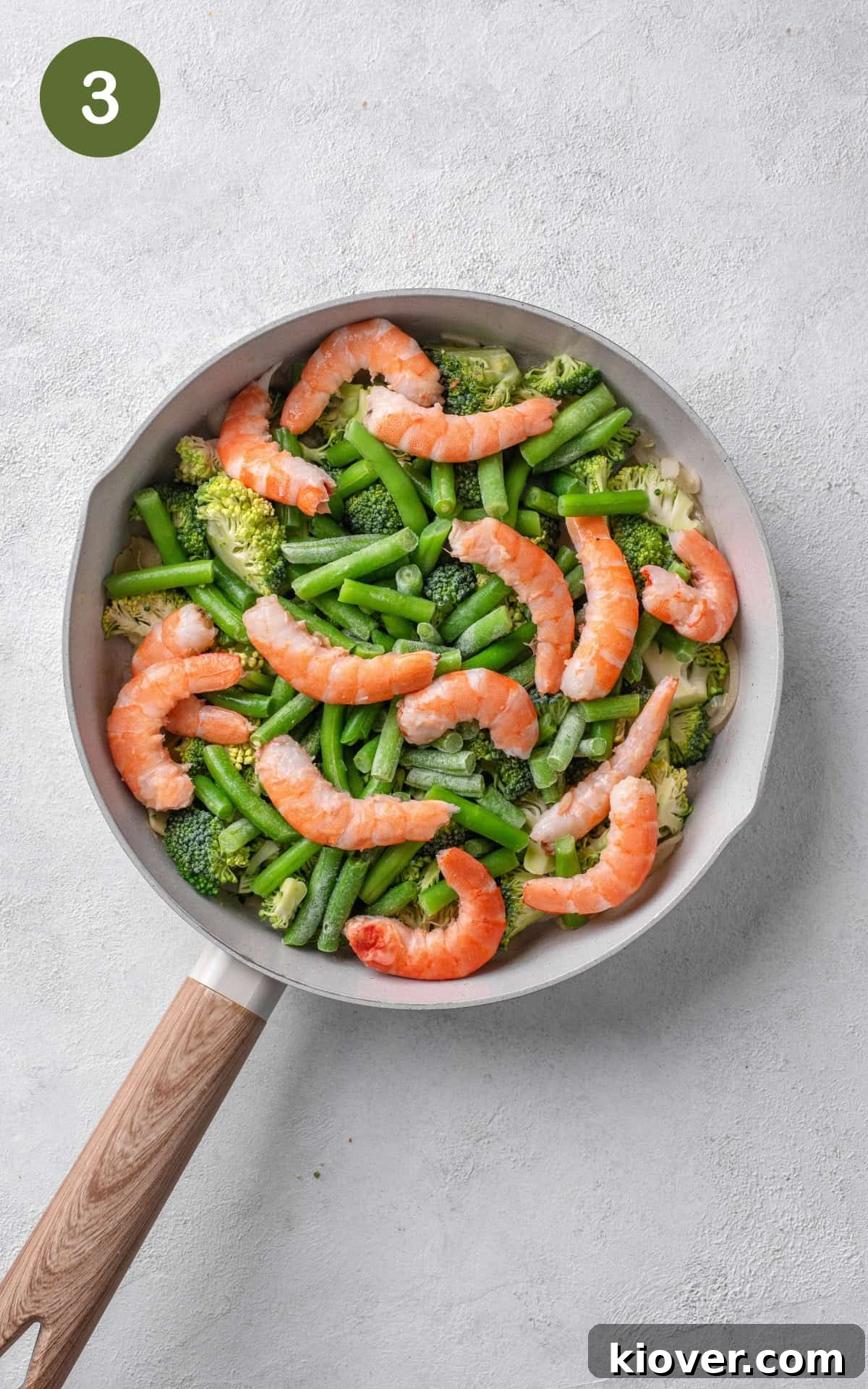 frying the veggies and prawns in a non stick pan, tossing them together.