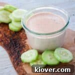 Chipotle Ranch Dressing and Dip on a cutting board with a cucumbers off to the side.
