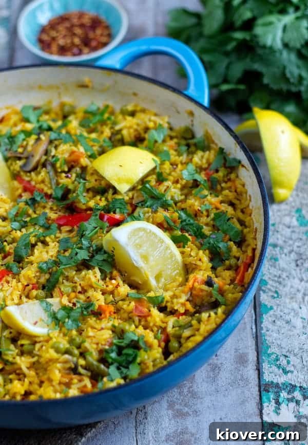 A side view of a steaming pan of Plant-Based Paella, showcasing the rich, colorful ingredients and fragrant rice.