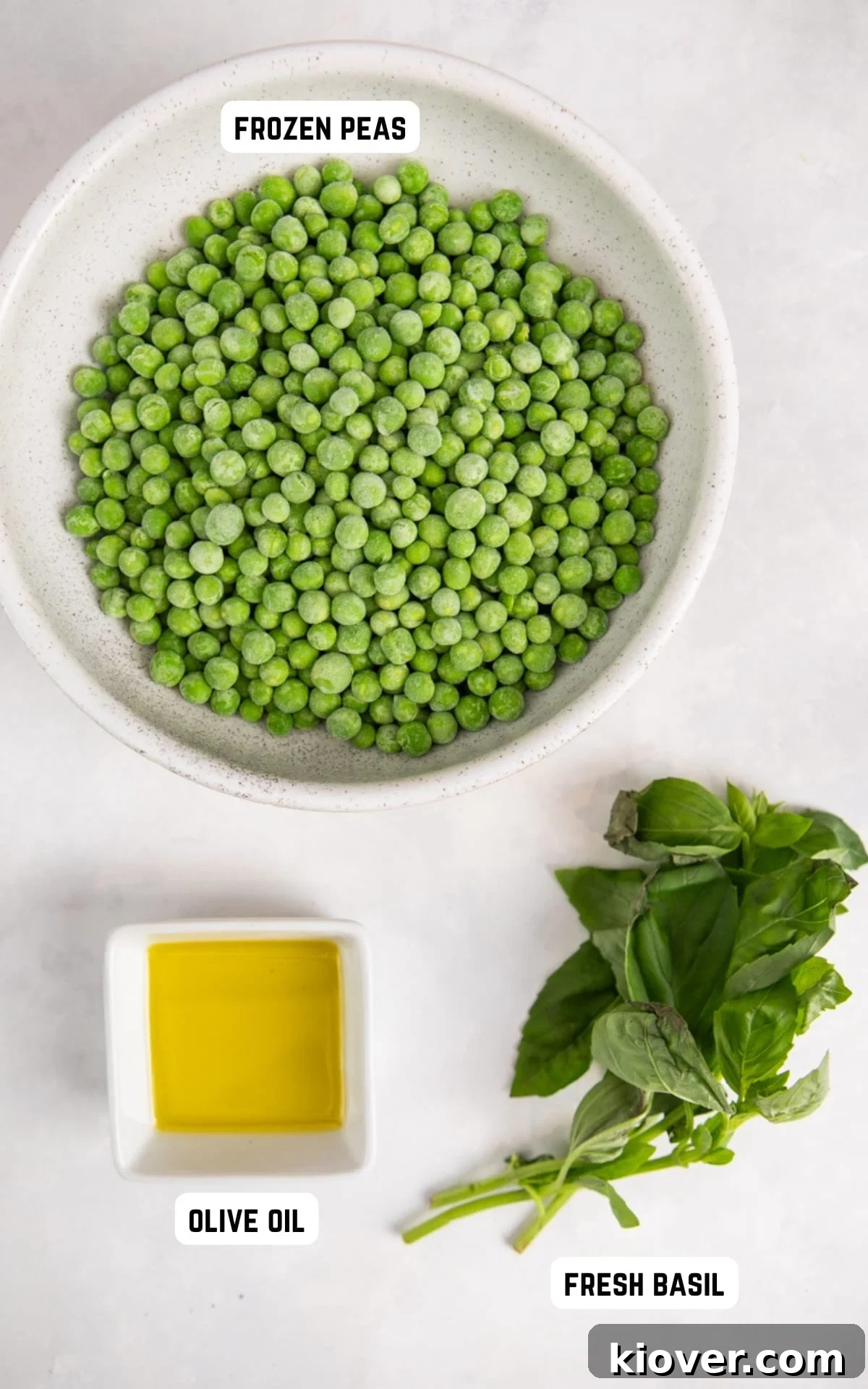 Essential ingredients laid out for making healthy mushy peas: frozen peas, olive oil, fresh basil, salt, and pepper.