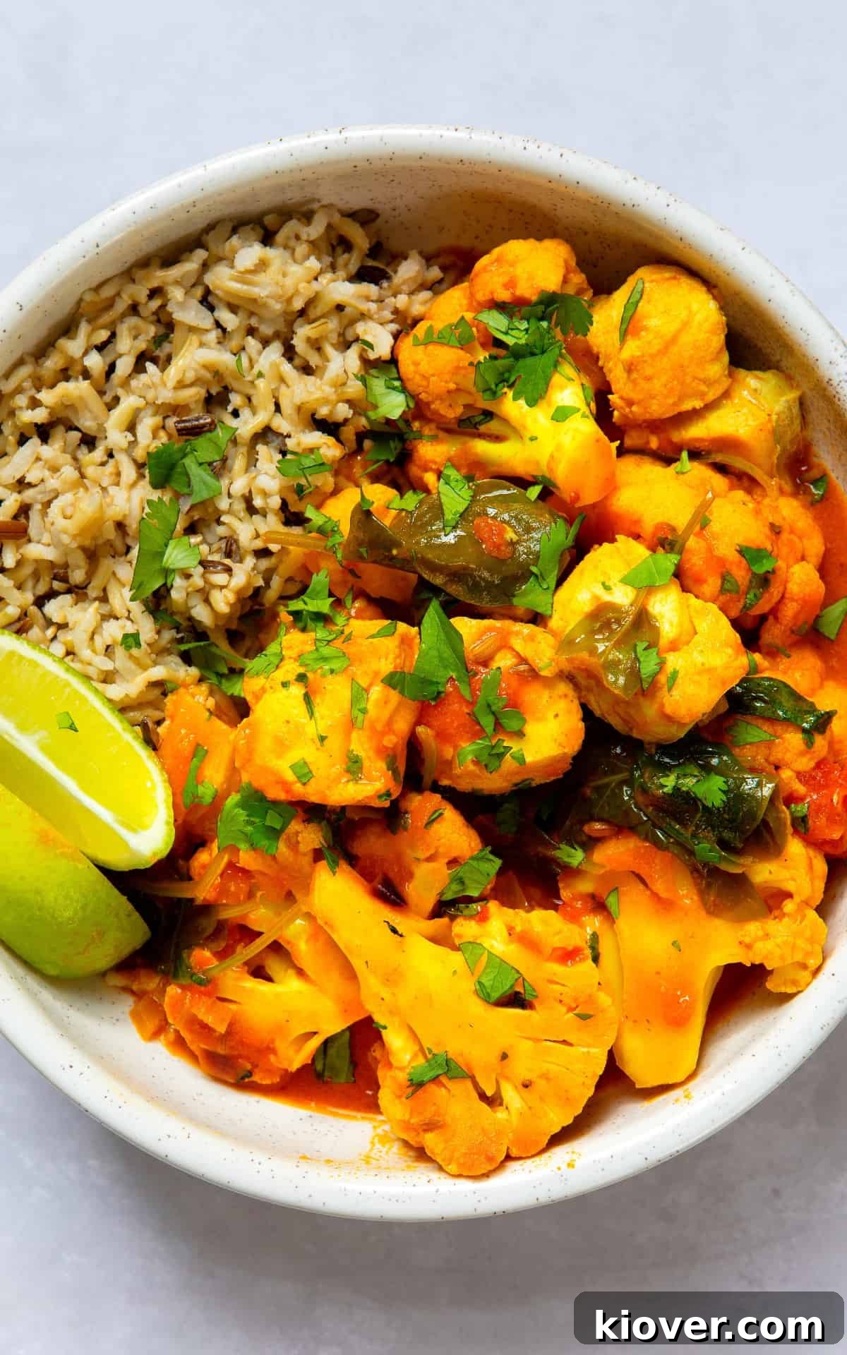 Cod and cauliflower curry with brown rice on the side, topped with fresh corriander.