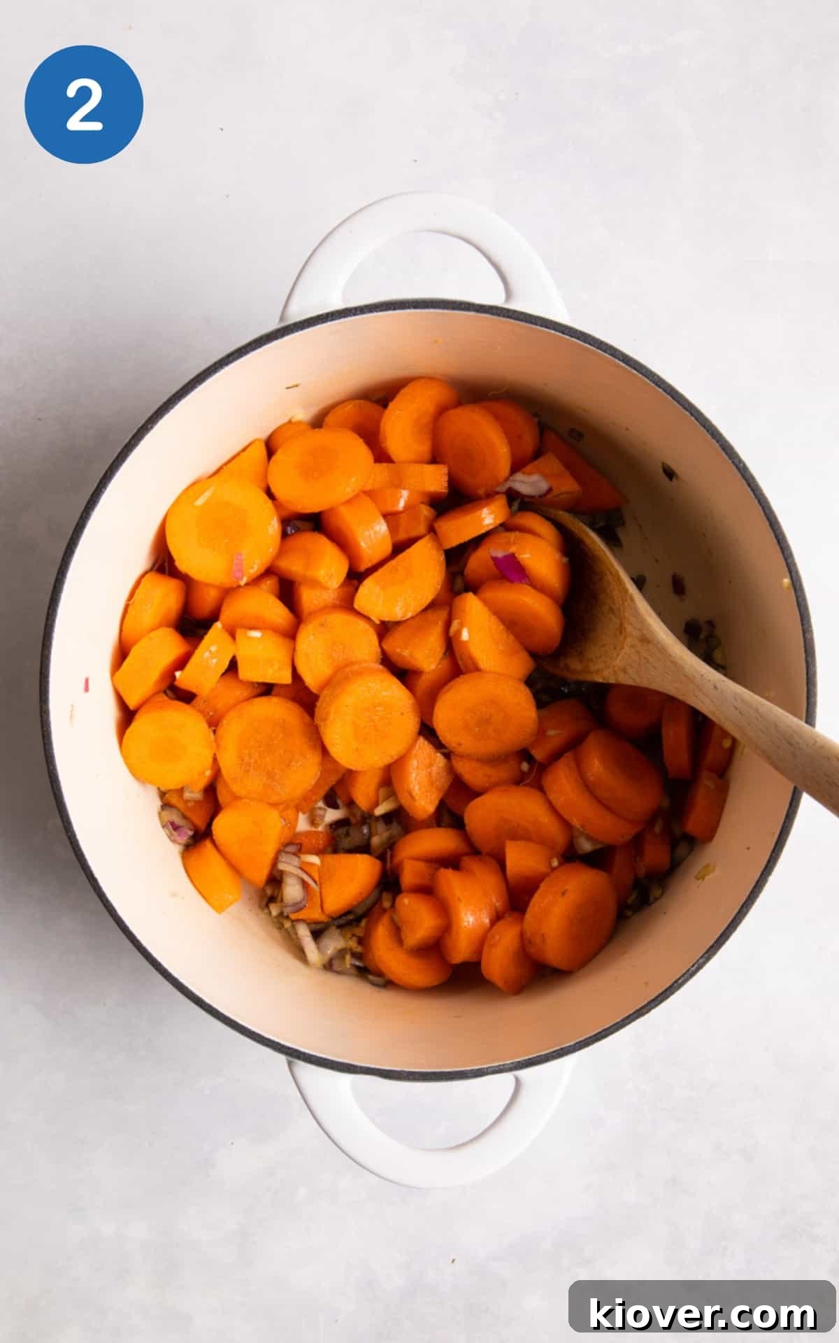 Frying off the garlic, onion, carrots, dried coriander in a large white pot.