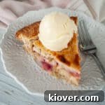One piece of rhubarb pie on a white plate, ready to be enjoyed.