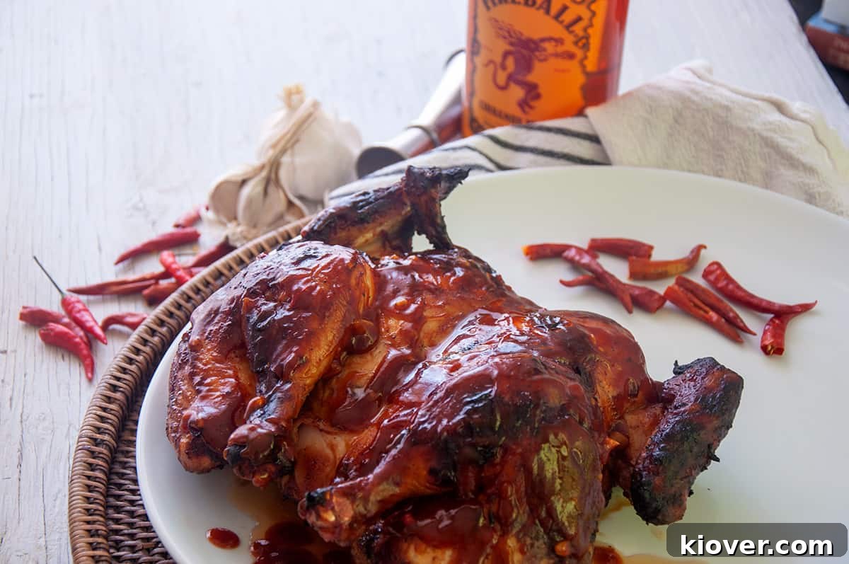 A whole spatchcocked grilled chicken, glistening with homemade BBQ sauce, ready to be served.