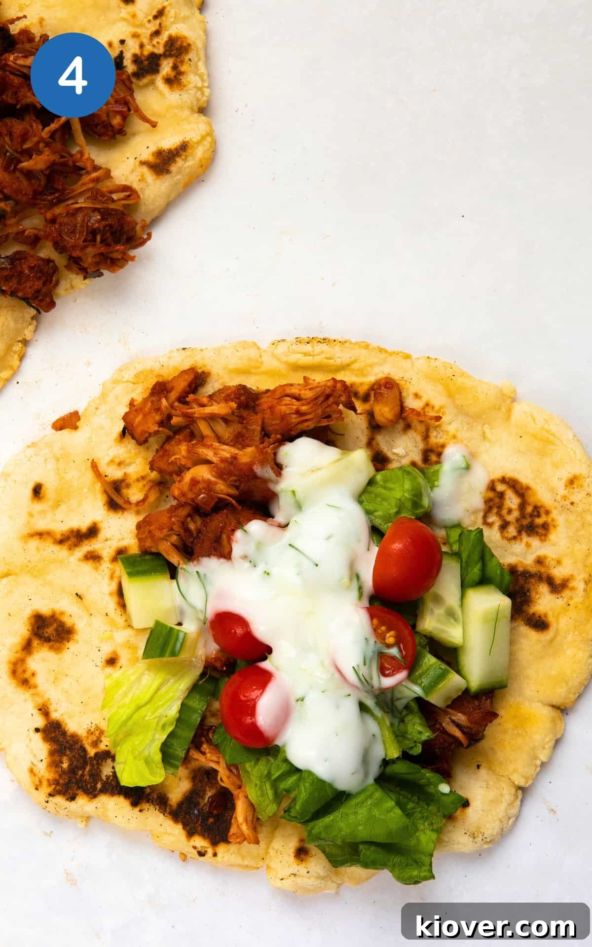 Jackfruit gyros served in flatbread with fresh vegetables and tzatziki.