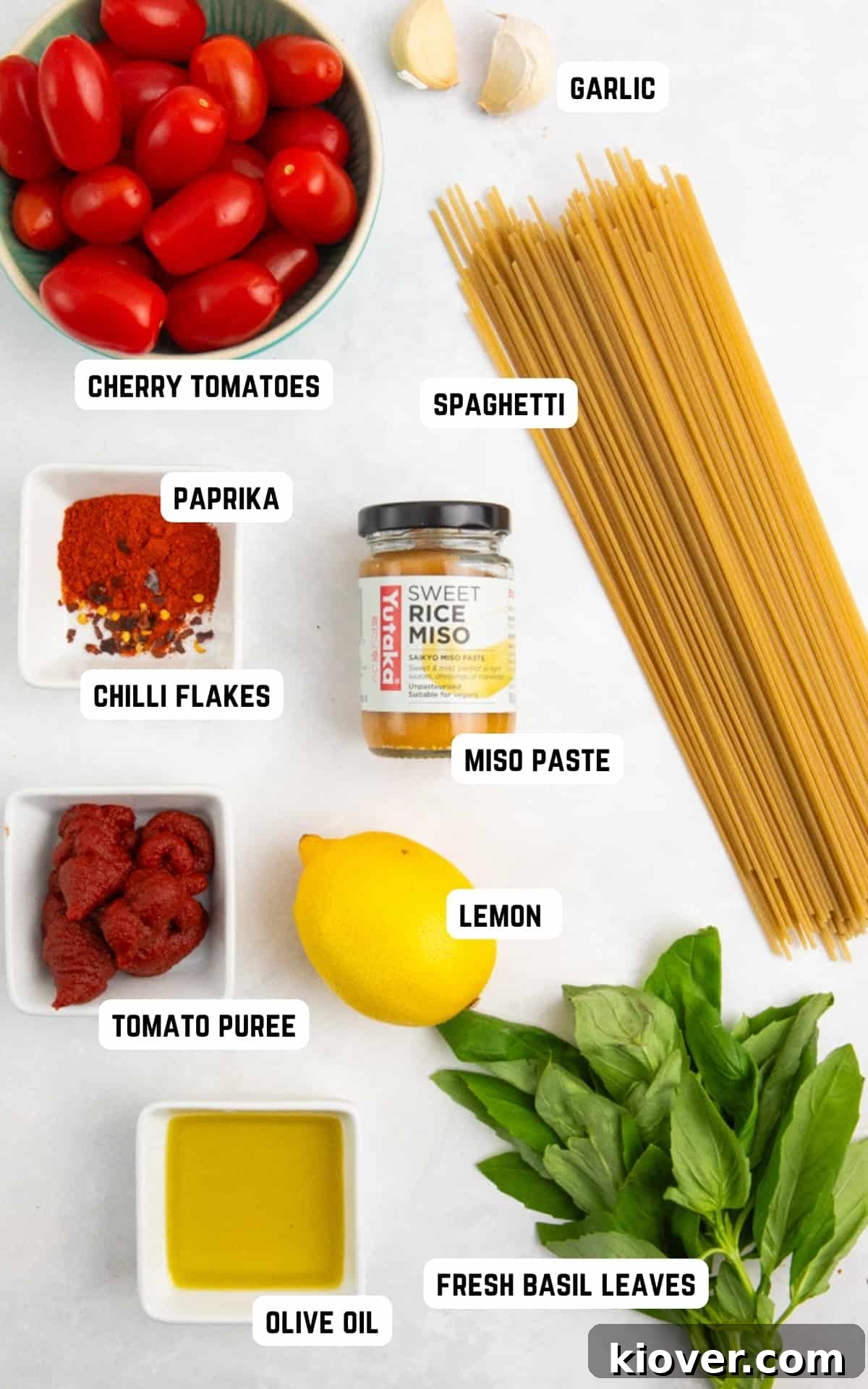 Fresh ingredients laid out for making Cherry Tomato Pasta Sauce: cherry tomatoes, garlic, basil, lemon, and spices.