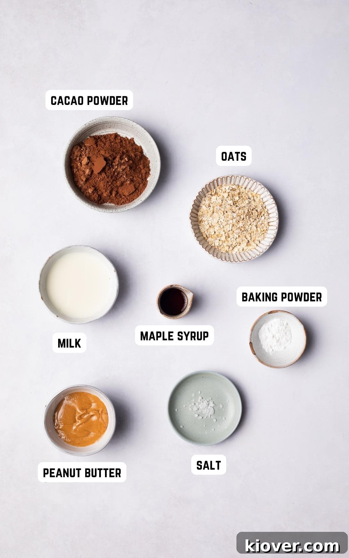 Collection of ingredients required to make the delicious Chocolate Pot: oat flour, cacao powder, baking powder, maple syrup, milk, peanut butter, and a pinch of salt.