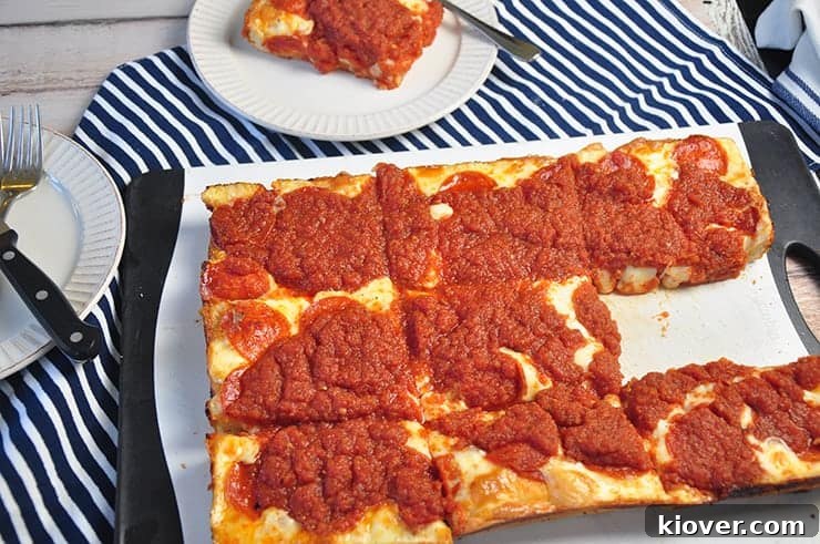 Detroit Style Pizza A Detroit Style Pizza on a cutting board with one piece taken out.