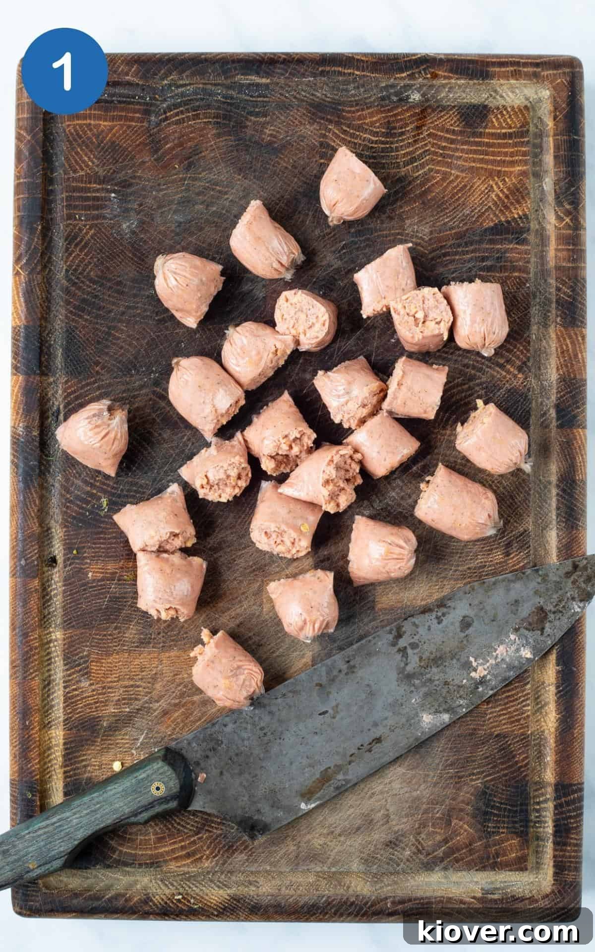 Hearty Sausage and Gnocchi Bake 4 slices sausages on chopping board with knife.