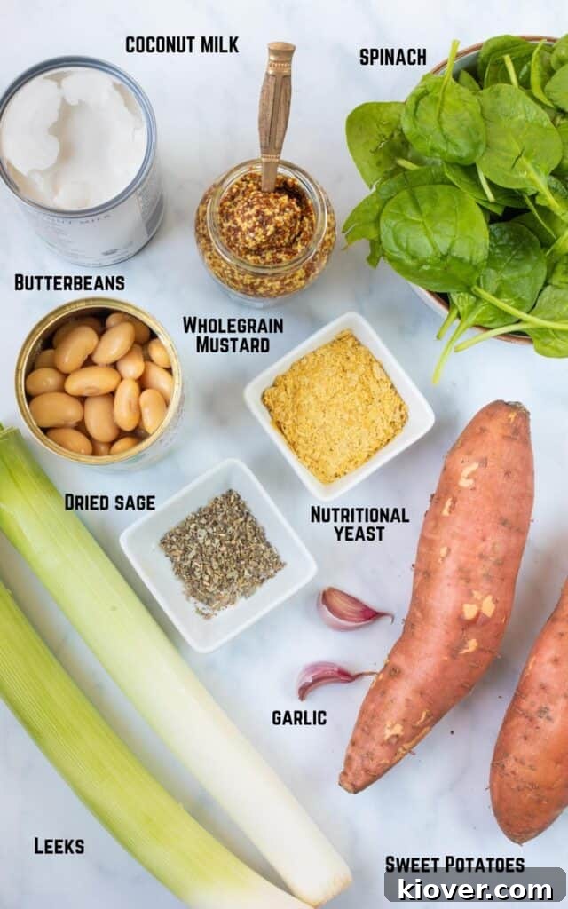 Overhead view of labeled ingredients for Butterbean and Leek Pie: Coconut Milk, Wholegrain Mustard, Spinach, Nutritional Yeast, Butterbeans, Dried Sage, Garlic, Sweet Potatoes, Leeks, arranged on a rustic wooden surface.