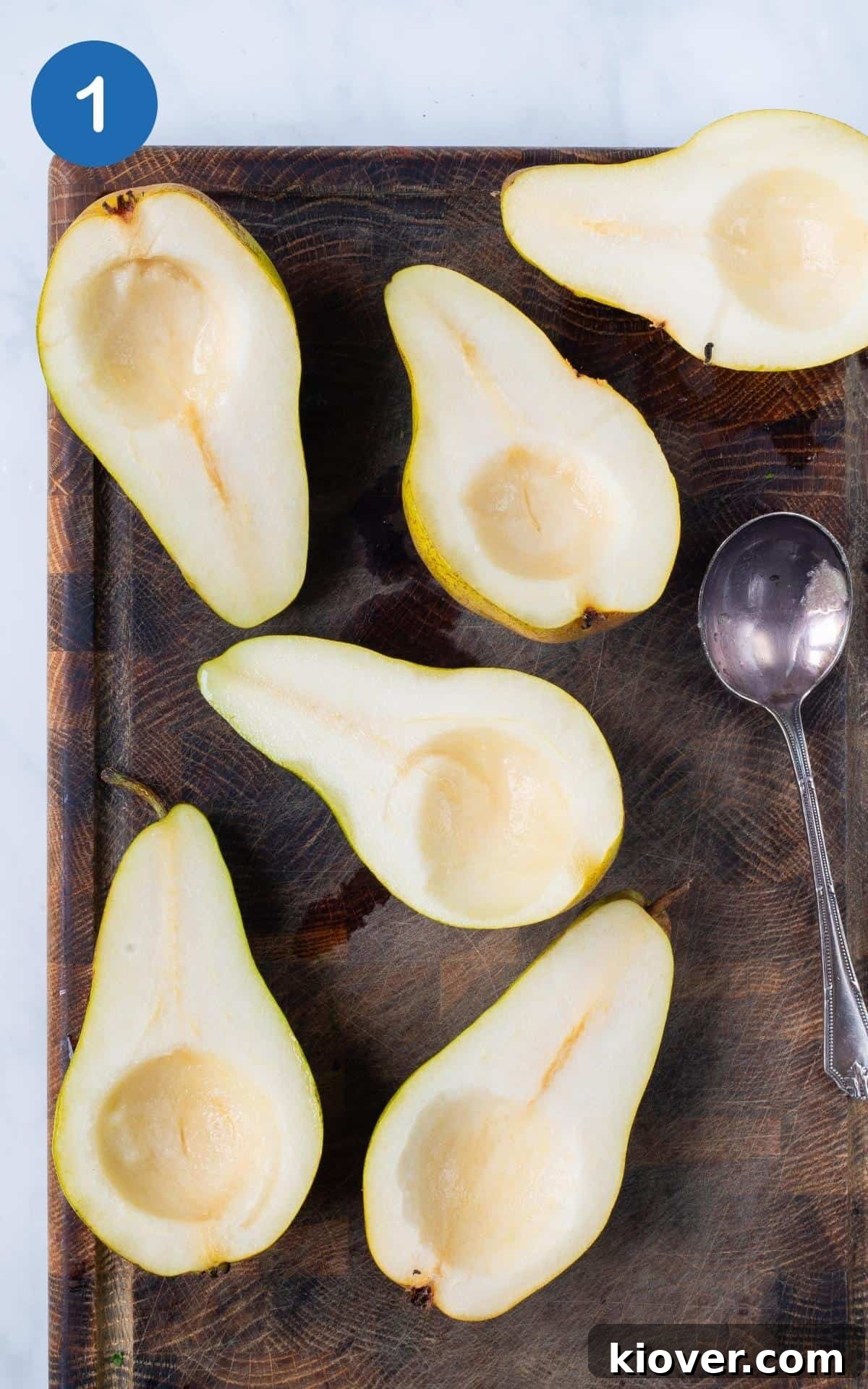 chopped pears on wooden chopping board with spoon.