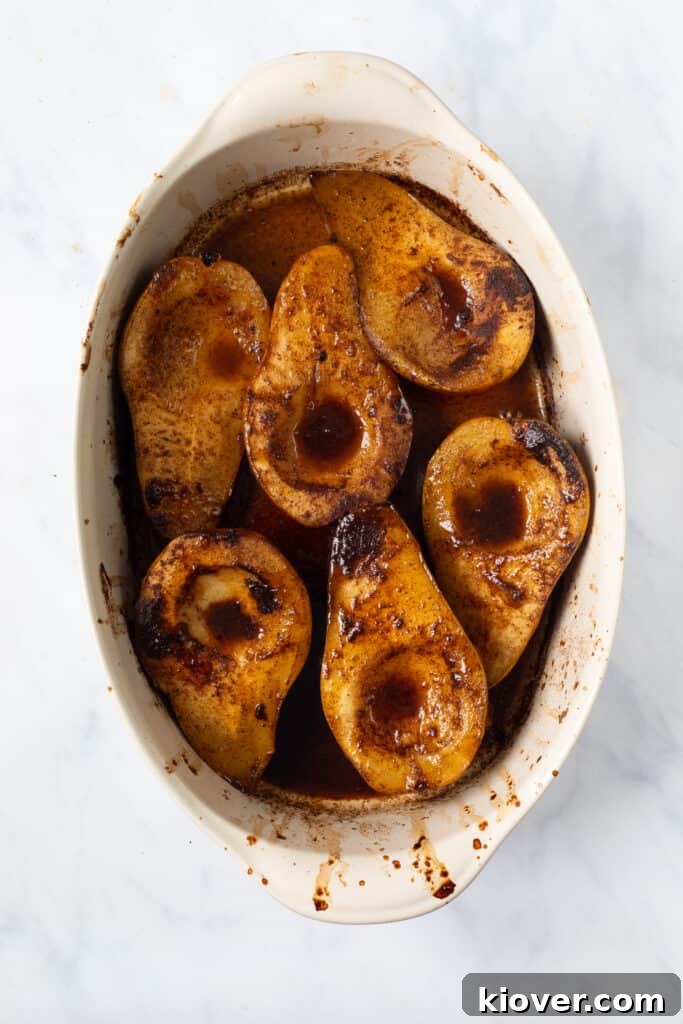 overhead view of baked spiced pears in white baking dish.