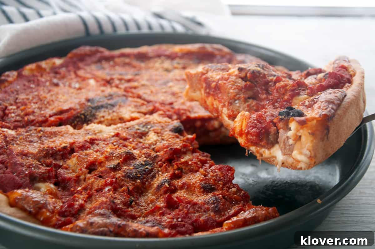 Chicago-style pizza A glorious slice of Chicago Deep Dish Pizza presented on a pristine white plate, showcasing its layers.