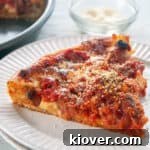 Chicago Deep Dish Pizza on a white table and a dish of cheese to the side.