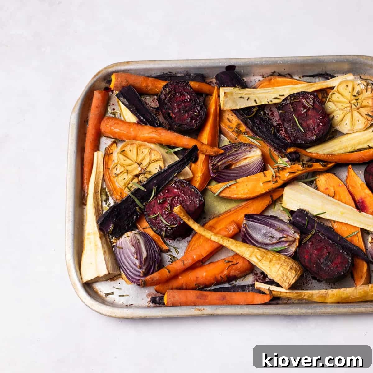 Vibrantly colored roasted root vegetables on a baking tray, ready to be served.