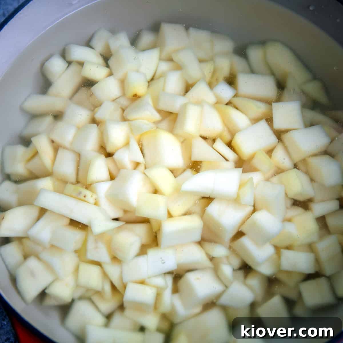 Peeled and cut potatoes soaking in a bowl of cold water.