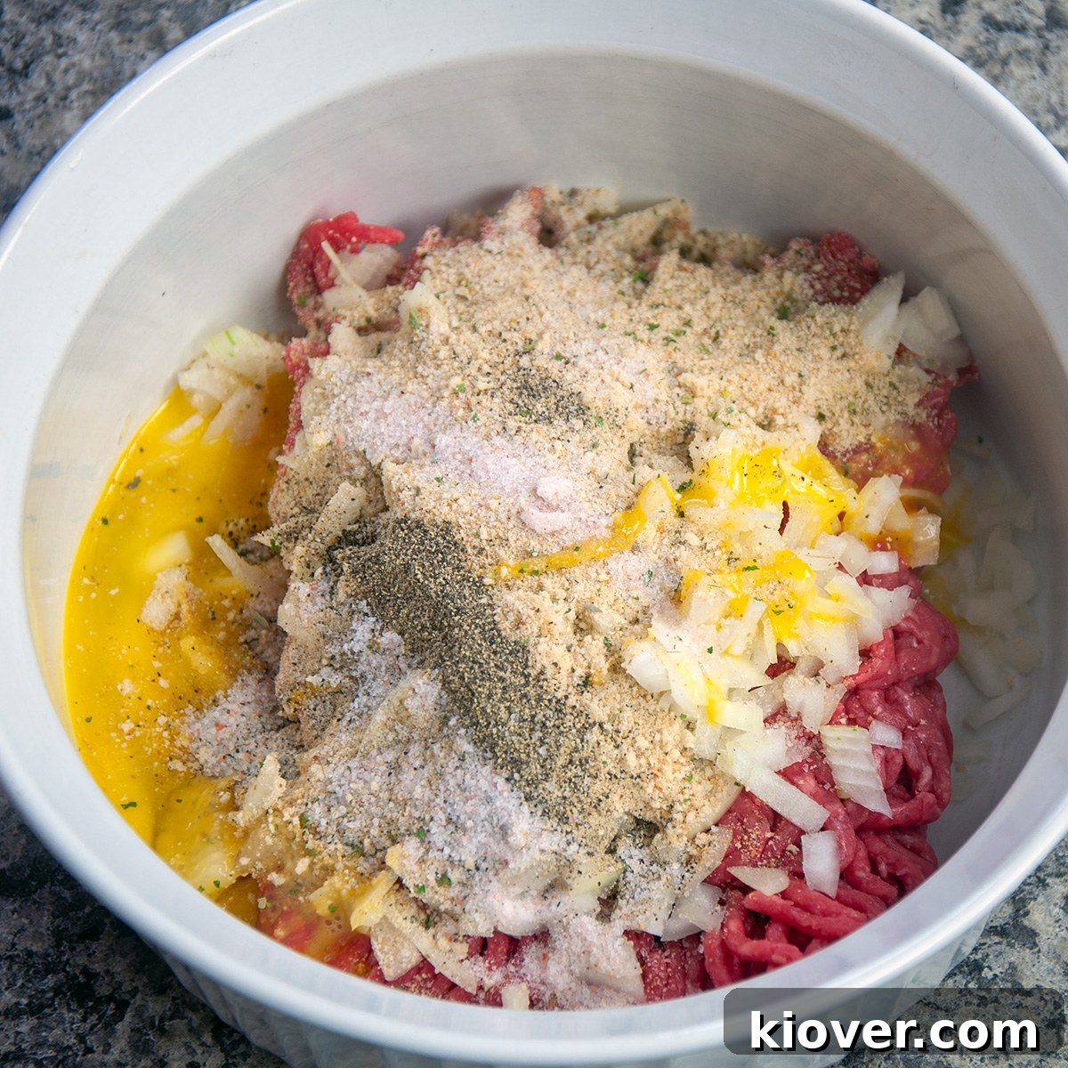Mixed Meat for Salisbury Steak Beef patty ingredients in a white bowl, ready for mixing.