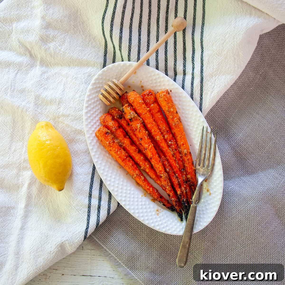 Grilled Carrots Grilled Carrots on a white plate with a lemon to the side.