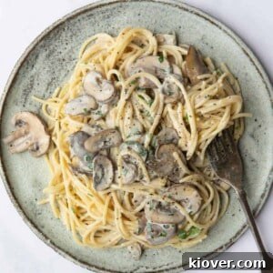 Vegan Mushroom Pasta served on a blue plate with a silver fork