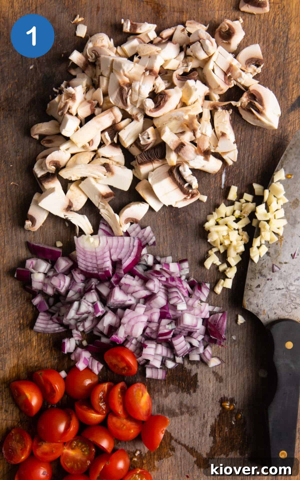 Plant-Based Lasagne Perfection 4 Freshly chopped vegetables, including mushrooms, tomatoes, onions, and garlic, ready for the lasagne sauce preparation on a wooden chopping board.