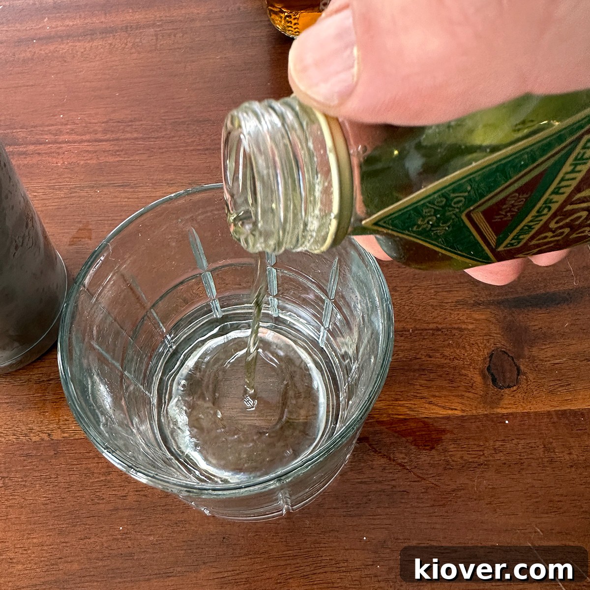 Adding a splash of absinthe to a chilled cocktail glass.