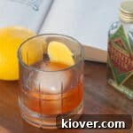 A Sazerac cocktail on a wood table.
