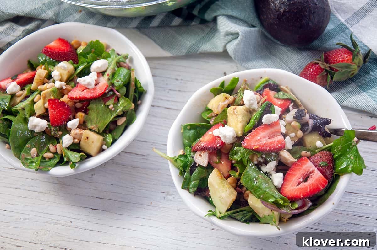 Colorful and Fresh Strawberry Salad Bowls Two bowls of strawberry salad with feta, avocado, and lettuce showing on top.