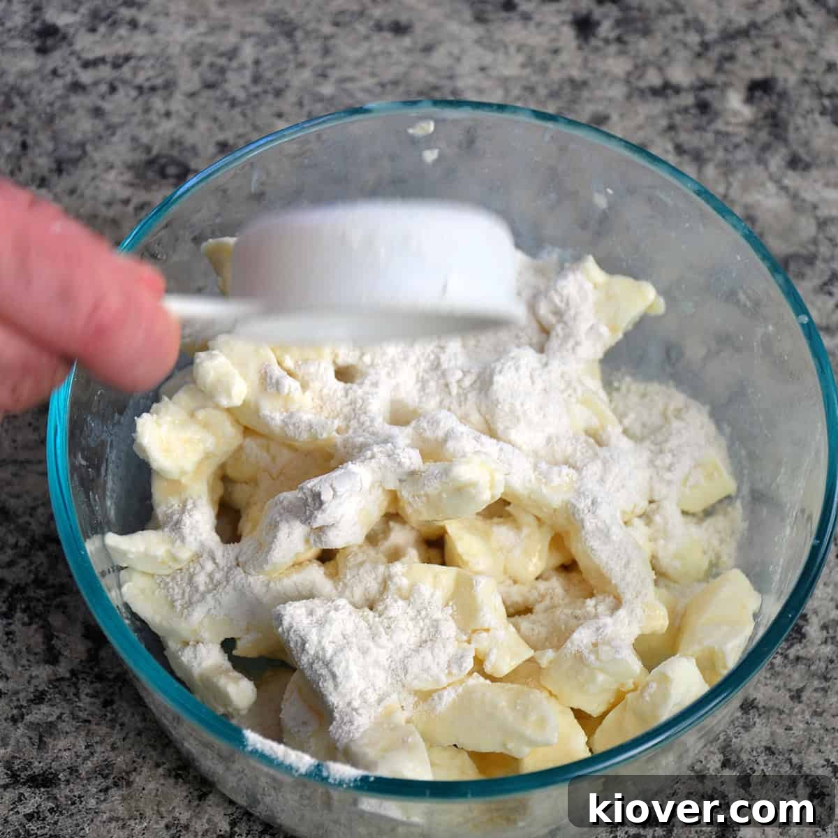 Cheddar cheese curds coated lightly in flour in a bowl.