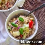 Fresh orzo salad in a white bowl.