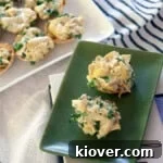 Two artichoke dip phyllo cups on a green plate.