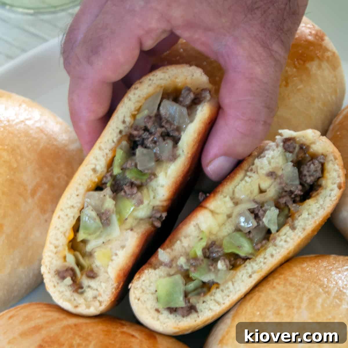 A hand picking up a Runza half.