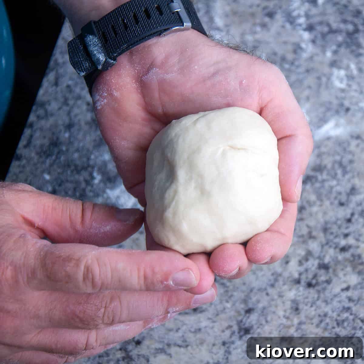 Hand holding a dough ball.