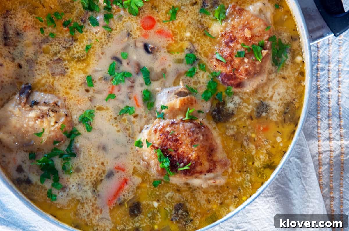 Traditional Chicken Fricassee Ready to Serve Sauce pan with traditional chicken fricassee resting on a white towel.