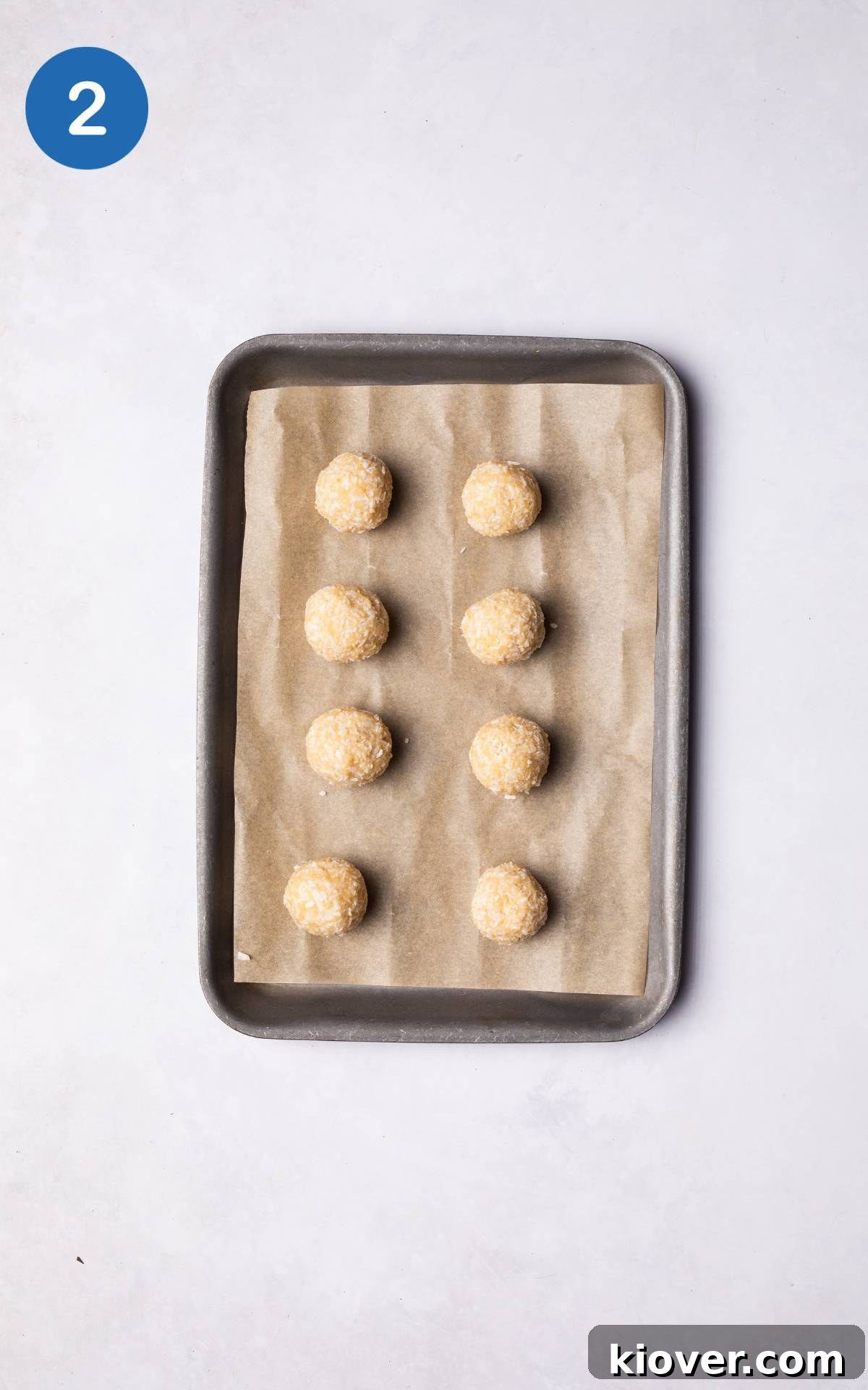 Rolled chocolate coconut balls arranged on a baking tray lined with parchment paper.