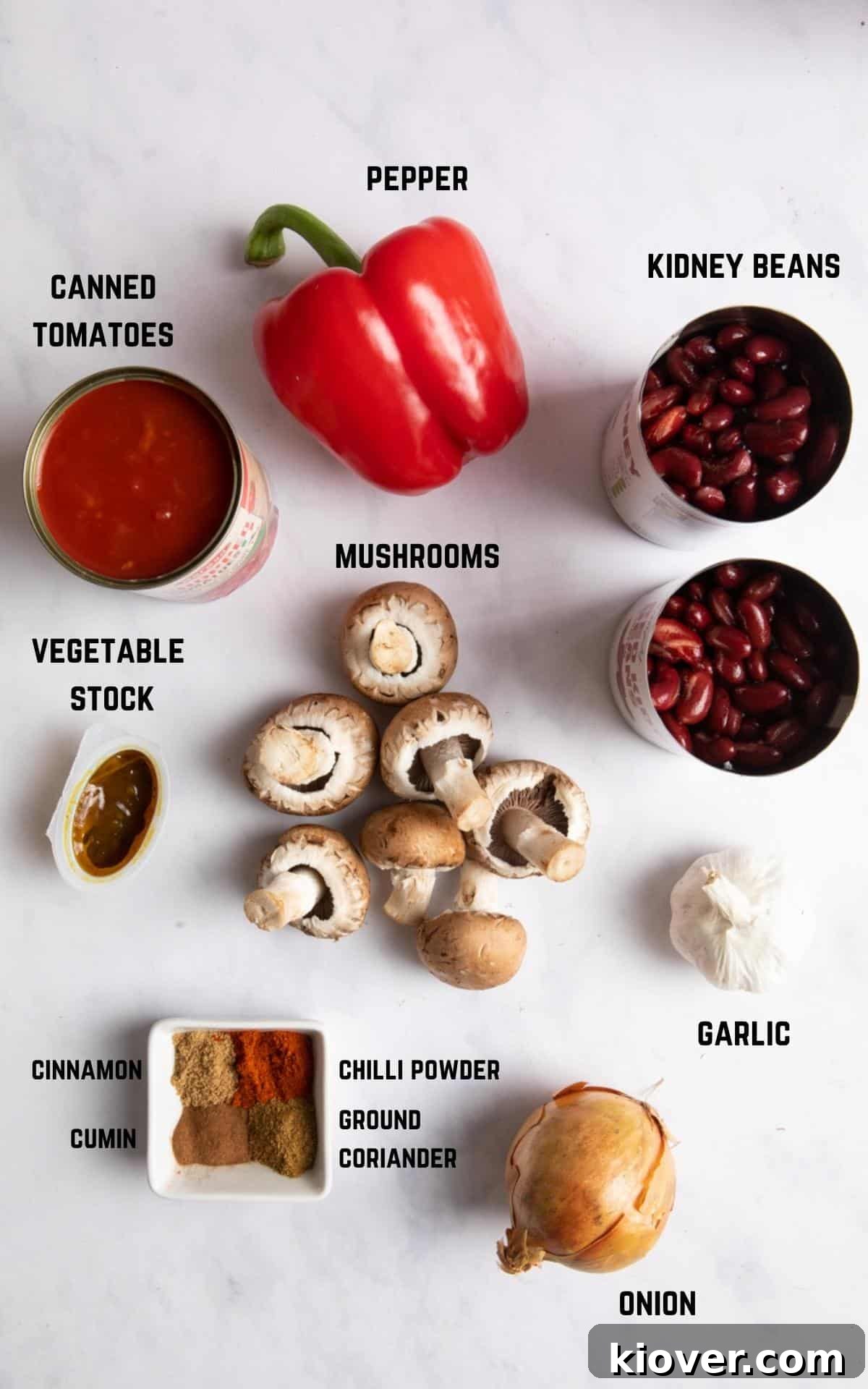 A beautiful flat lay of fresh ingredients including mushrooms, bell peppers, onions, garlic, and spices, all ready to be transformed into a delicious vegan chilli.