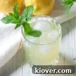 A single glass of Honey Lemonade with a sprig of mint in it.