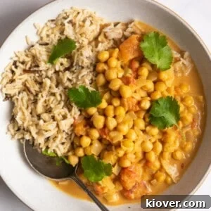Hearty Slow Cooker Chickpea Curry 7 Chickpea curry with rice in a shallow white bowl.