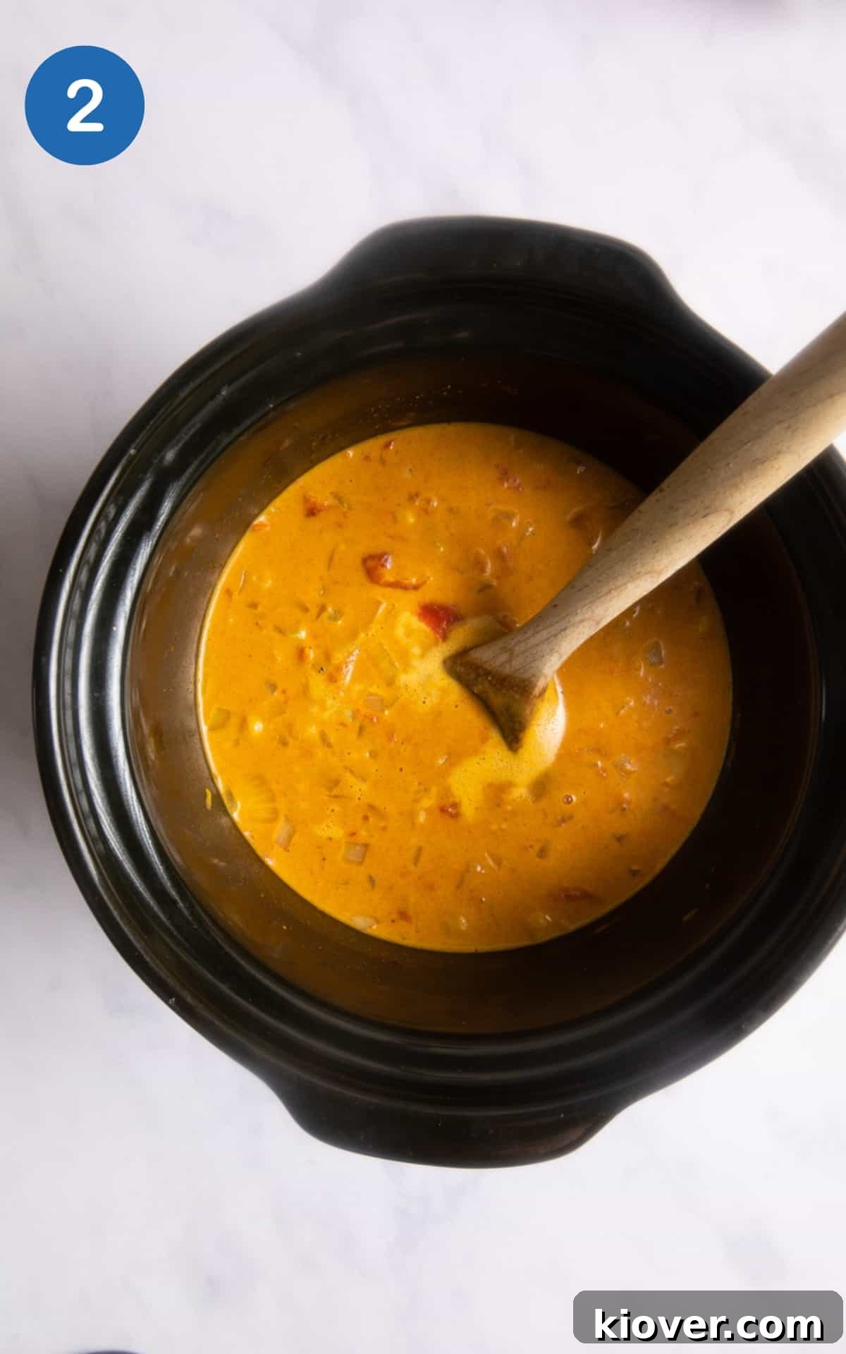 Hearty Slow Cooker Chickpea Curry 5 Curry sauce and a wooden spoon in a slow cooker.