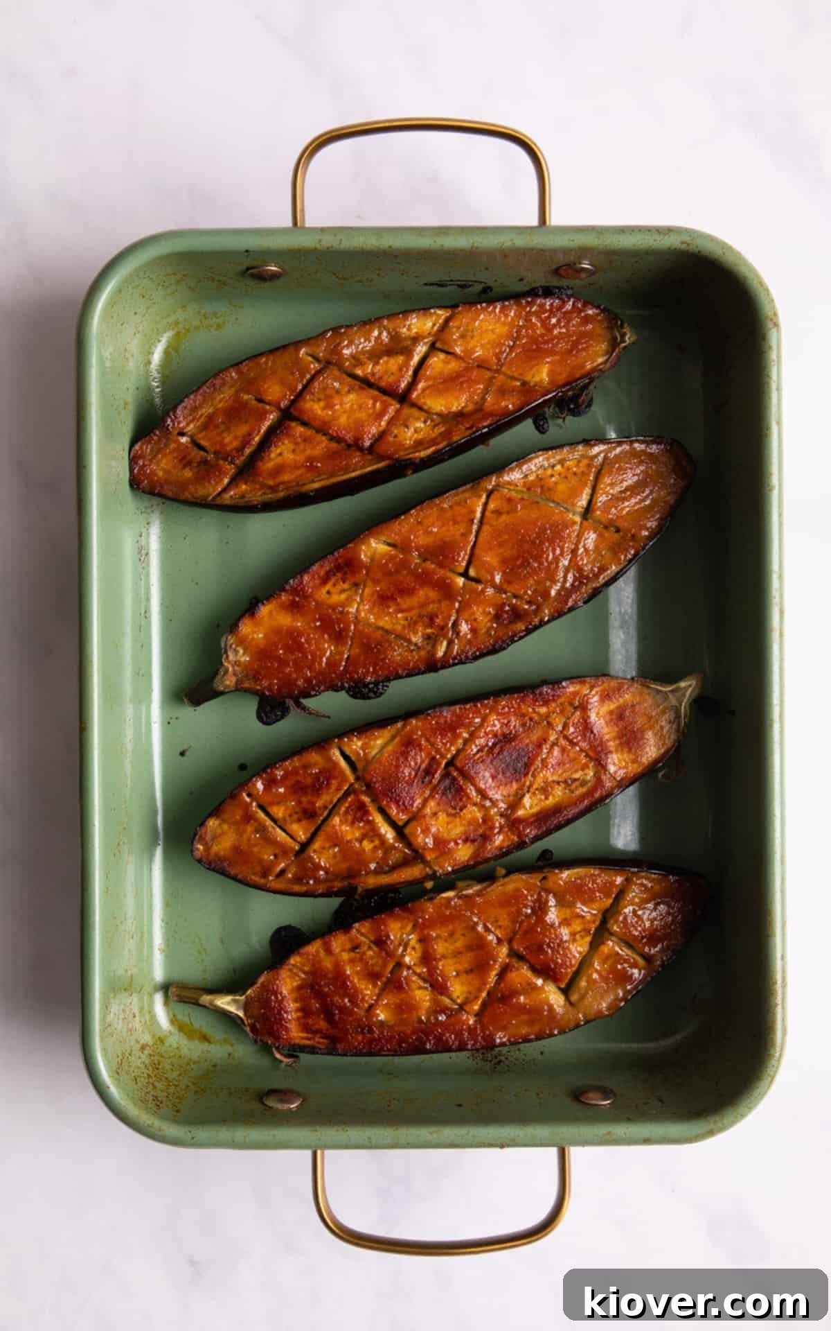 Perfectly Sweet and Savory Miso Glazed Aubergine Nasu Dengaku 7 Freshly oven-baked miso aubergine halves, still in their green baking tray, showcasing their rich, caramelized glaze and tender texture, ready to be served.