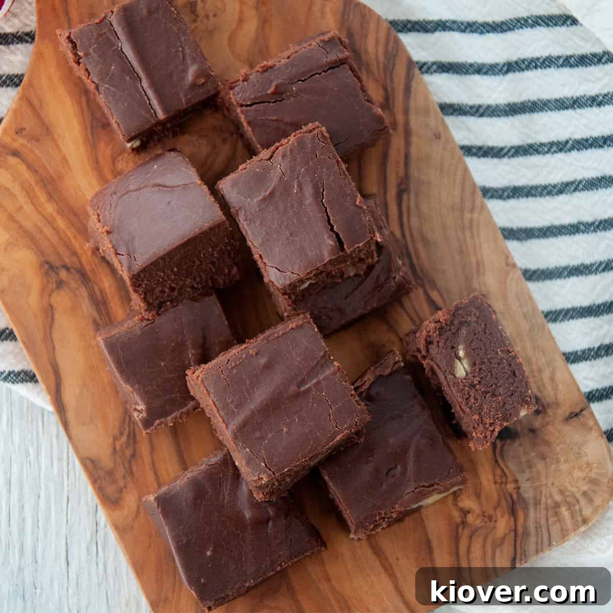 Several beautiful pieces of Velveeta fudge displayed on a wooden cutting board, ready for serving.