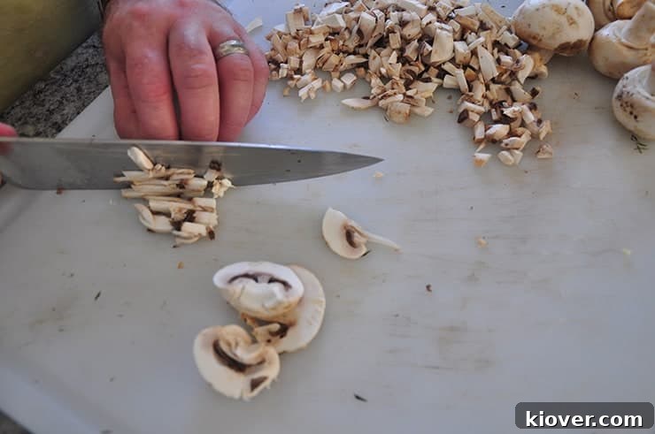 Carefully chopping fresh mushrooms for a homemade cream of mushroom soup base.