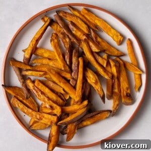 sweet potato fries on white plate with orange rim.