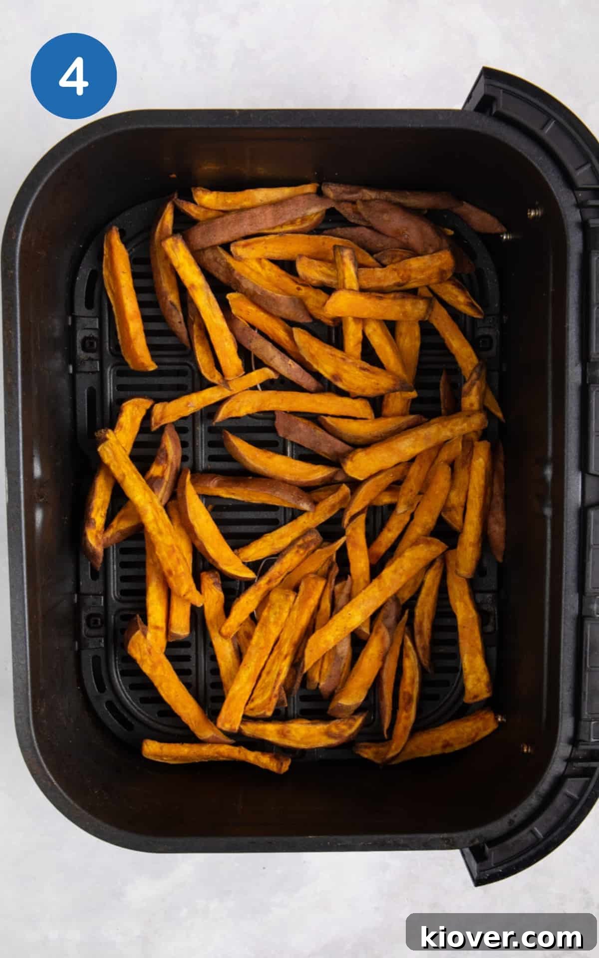 Cooked sweet potato fries in black air fryer.